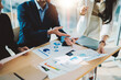 © Natee Meepian - Business People Meeting to analyse and discuss and brainstorming the financial report chart data in office Financial advisor teamwork and accounting concept