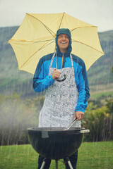 Canvas Print - Its like liquid sunshine. Shot of a man happily barbecuing in the rain.