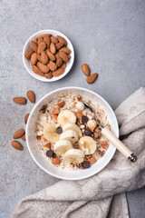 Wall Mural - Healthy breakfast with oatmeal, nuts, banana and chocolate drops