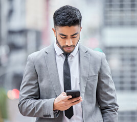 Poster - You have until the end of the business day. Shot of a young businessman using his smartphone while walking outside.