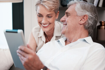 Wall Mural - That smile covers my heart. Shot of a mature couple using a digital tablet at home on the sofa together.