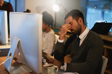 Aufkleber - Feeling the pressure. Shot of a stressed out young businessman working late at the office with his colleagues.