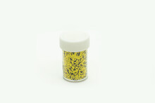 Photo Of Yellow Sequins In A Jar On White Background