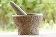 Closeup of a pestle and mortar made of stone on a blurred background