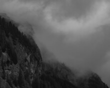 Grayscale Shot Of The Foggy Mountainside.