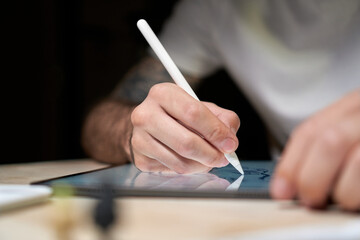 Closeup shot on man's hand with pen writing on touch screen