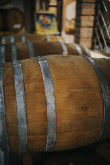 Vertical shot of wooden wine barrels in a winery storage