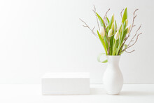 Empty White Box And White Tulips In A Vase On A Light Background. Mockup Banner, Podium For Display Of Advertise Product