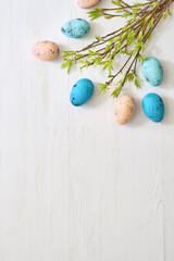 Wall Mural - branches with green leaves and easter eggs on a light background. happy easter flat lay concept