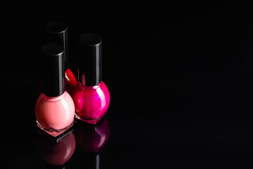 Colorful nail polish bottles on black table.