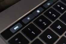 Closeup shot of details of a touch bar and a keyboard on a laptop