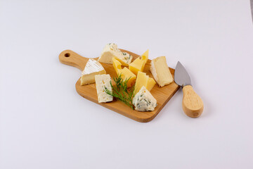 Wall Mural - Varieties of cheese on a cheese-board isolated on a white background