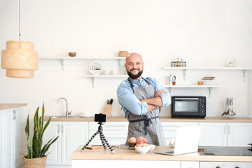 Wall Mural - Male chef with tasty peach muffins in kitchen