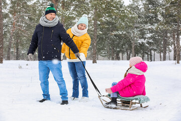 Poster - Little girl with her grandparents sledging on snowy winter day