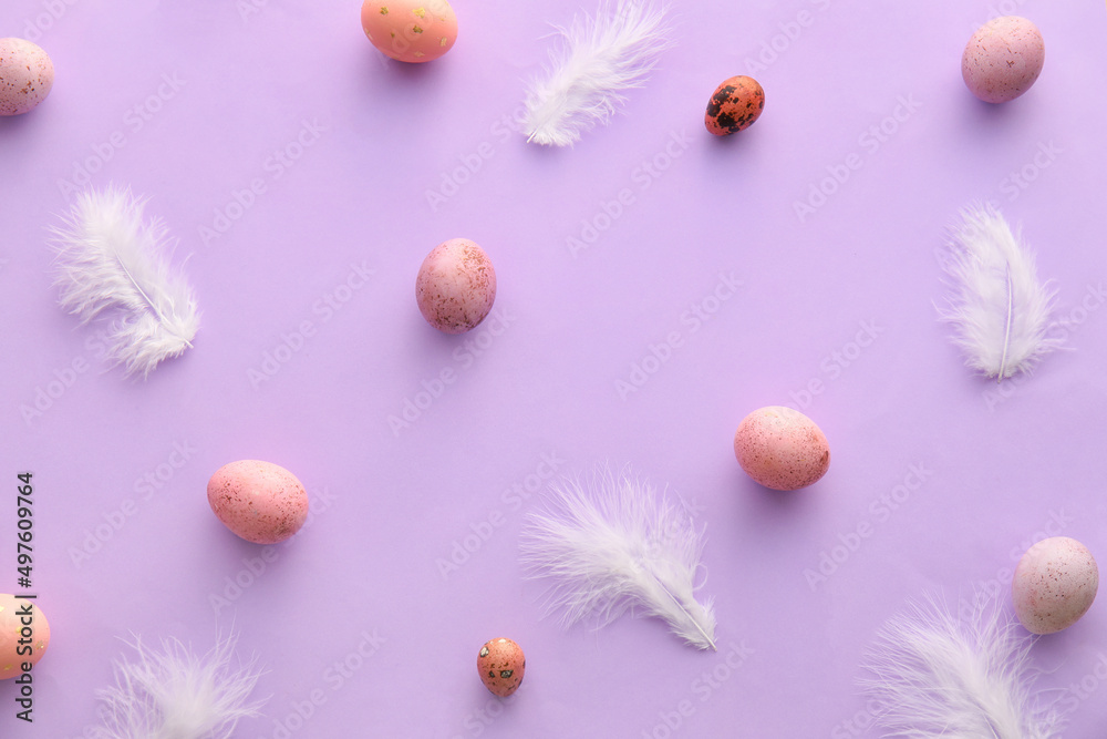 Composition with painted Easter eggs and feathers on lilac background