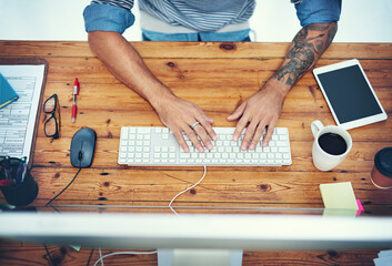 Poster - All the tools to keep him productive. High angle shot of a businessman using a computer at his desk in a modern office.