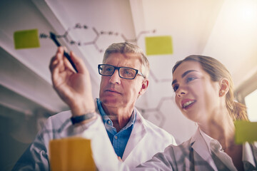 Aufkleber - This makes a whole lot of sense. Shot of two focused scientists working together solving equations on a glass wall in a laboratory.
