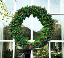 Close-up Of Green Christmas Wreath On Resort Window