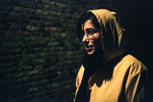 Woman In The Street At Night Wearing A Yellow Raincoat 