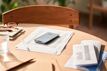 Calculator On Smartphone And Documents On Table