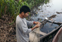 Peruvian Man Collecting Fish From The Net