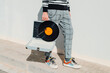 © Juan Moyano/Stocksy - man carrying a portable turntable