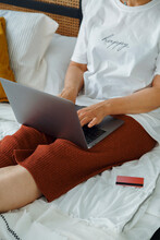 Female Shopper Using Laptop On Bed