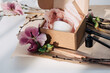 © Liliya Rodnikova/Stocksy - Gift box with soy wax candle and flowers around