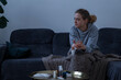 © Danil Nevsky/Stocksy - Sick woman with glass of tea on sofa at home