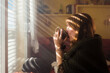 © Ibai Acevedo/Stocksy - Woman drinking coffee during winter morning