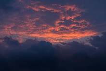 A Cloud Filled Sky With A Flash Of Red  Sunlight