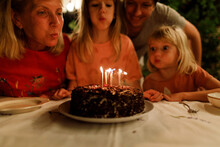 A Family Is Blowing Candles On The Cake