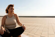 © Valentina Barreto/Stocksy - curvy woman in activewear sitting outdoor