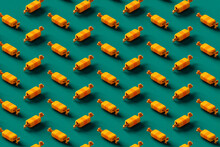 Pattern Of Yellow And Orange Candies On A Green Background