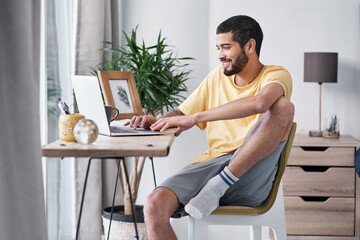 Aufkleber - Thank goodness for this work from home gig. Shot of a young man using a laptop while working from home.