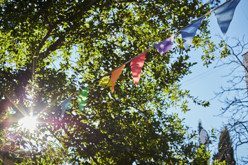 Festive fabric garlands against the blue sky in summer. The concept of celebration, rest, joy and happiness. Front view.