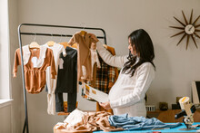 Pregnant Business Owner Reviewing Clothes Design