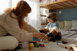 © Tanya Yatsenko/Stocksy - A boy and his mom are playing with toys at home