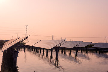 Wall Mural - Transmission towers and solar panels are clean energy concepts. Sunset background