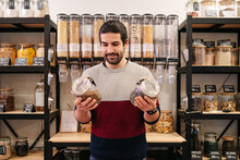 Happy Man Holding Cereal Jars In Eco Friendly Store