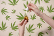 © Marc Tran/Stocksy - Hand holding a bottle of hemp oil, CBD, canabis or canabidiol