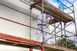 Maler beim Fassadenanstrich eines neuen Wohnhauses