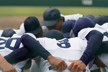 野球の試合で円陣を組み精神統一する野球選手たち