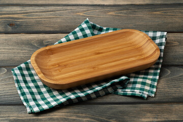 Wooden board with kitchen napkin on dark wooden table