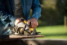 Close-up Of Raftsman Working With Circular Saw At Construction Site