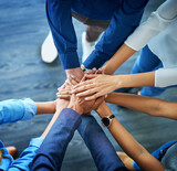 Lets awaken the team spirit. High angle shot of a group unrecognizable businesspeople joining their hands together in unity.