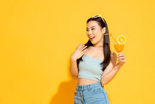 Summer Portrait Of Pretty Asian Girl With Orange Juice Drink In Isolated Yellow Color Studio Background