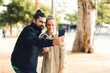 © David - Man and woman taking a selfie in a urban park