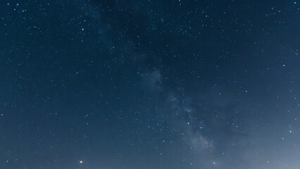brown tower with a blue sky with stars and the milky way