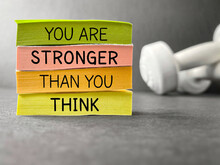 Inspirational And Motivational Quote Concept. You Are Stronger Than You Think Text On Notepaper Background.